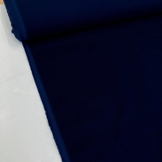 Close-up of dark blue cotton needlecord fabric on a white background