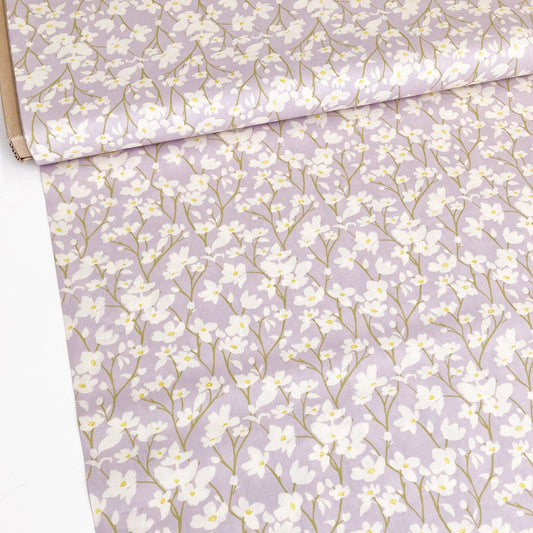 Floral cotton fabric with cream flowers on a lilac background.