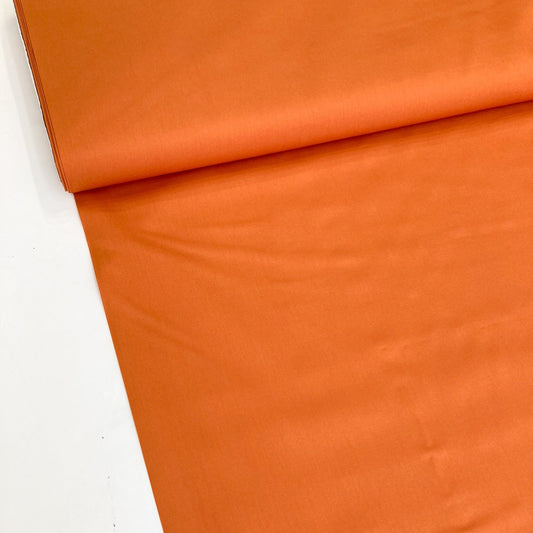 Art Gallery Fabrics burnt orange quilting cotton solid against a white background