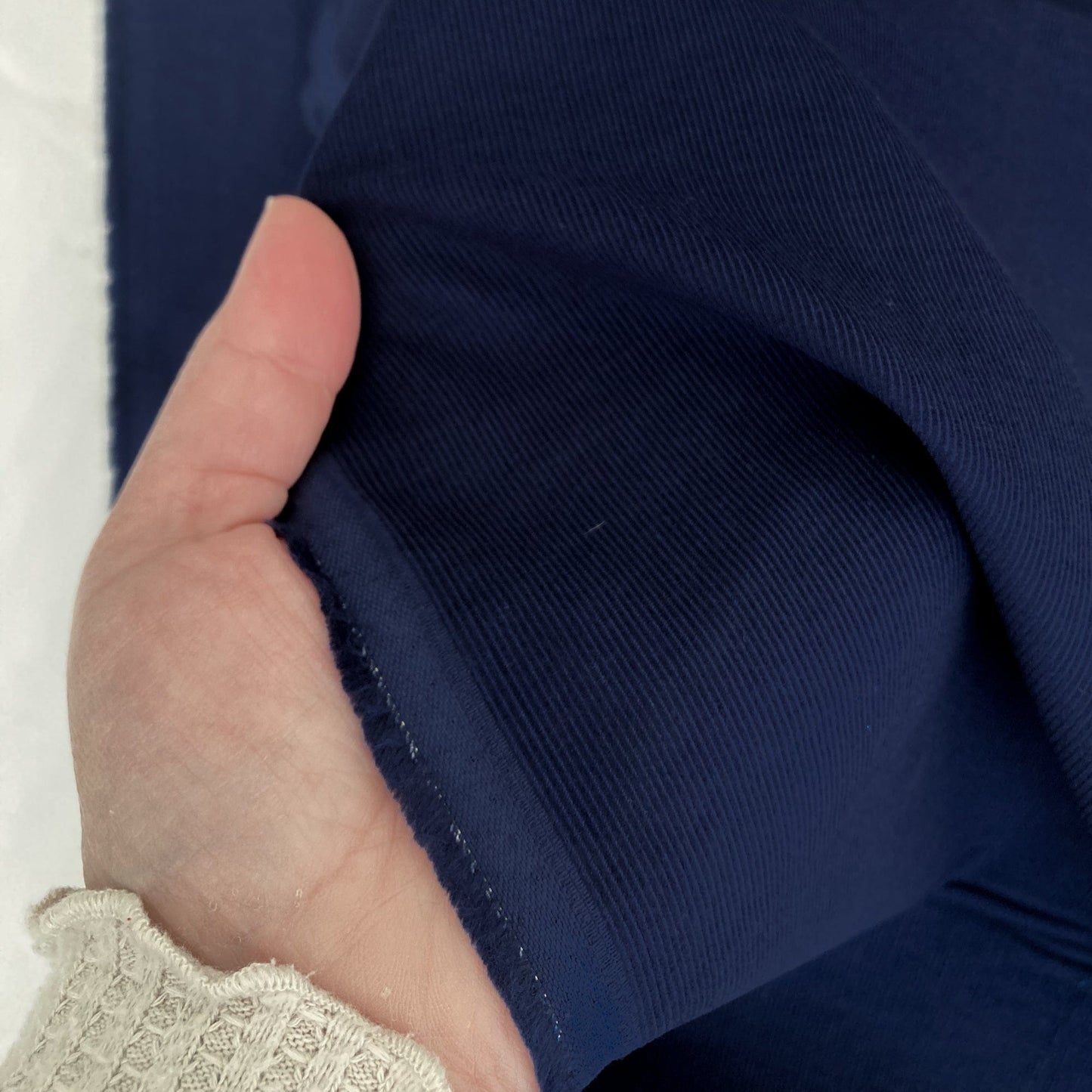 Hand holding navy blue needlecord fabric