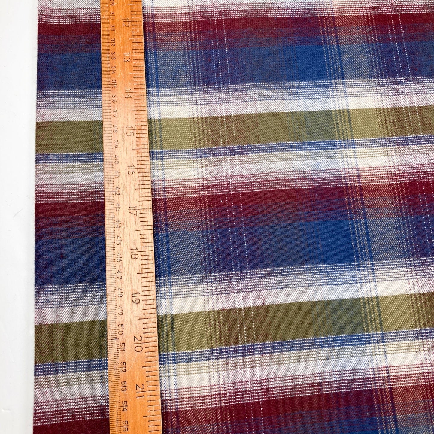 Flannel check fabric with a ruler for scale on a white background