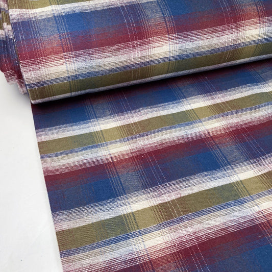 Bolt of plaid flannel fabric with blue, red, and green colors on a white background