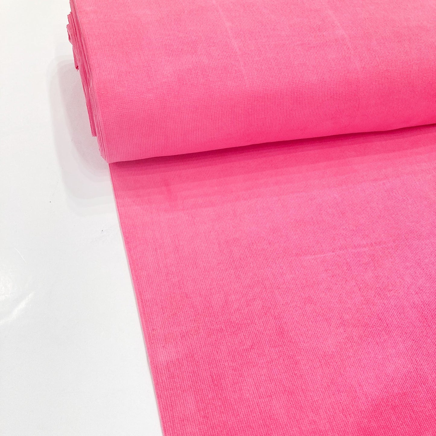 Bolt of bright pink cotton corduroy fabric