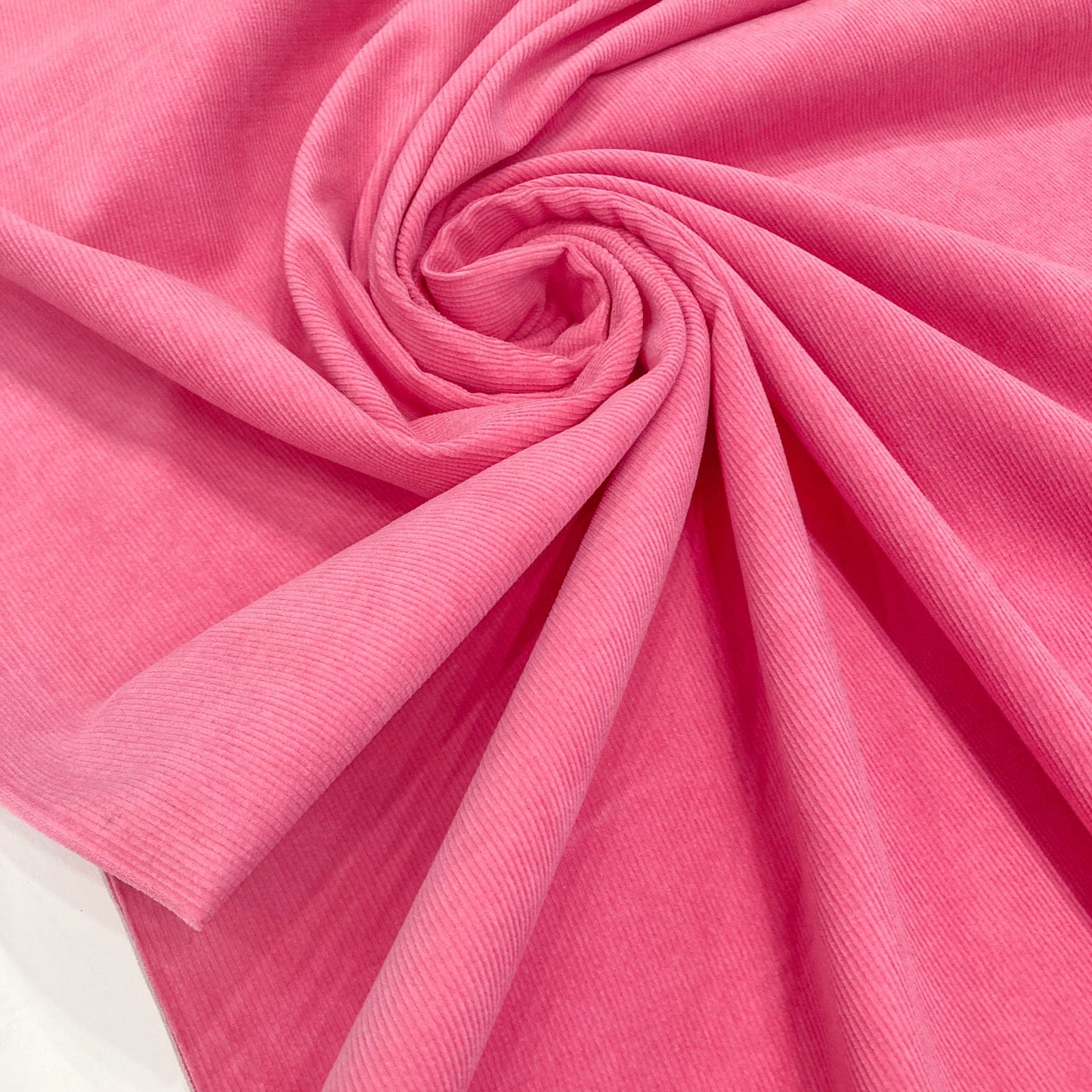 Close-up of swirled bright pink cotton corduroy fabric