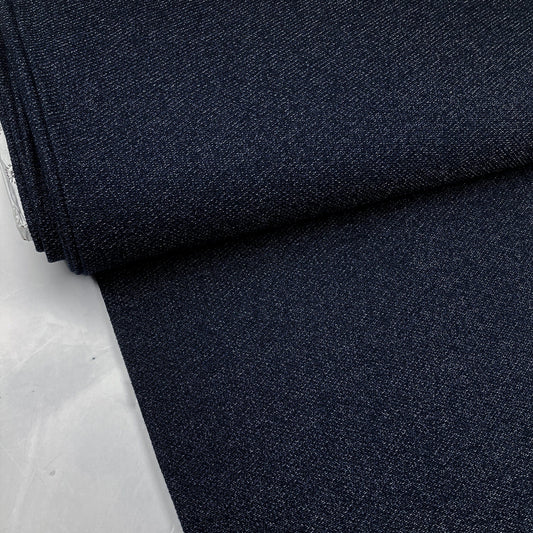 Bolt of dark blue knit fabric on a white surface
