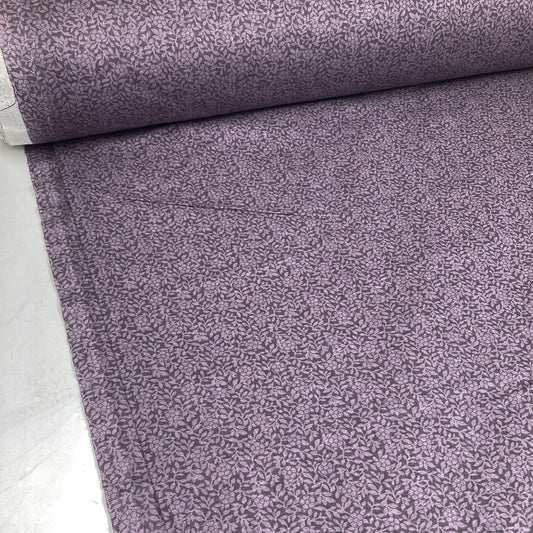 Bolt of urple cotton quiltback fabric with a small floral pattern