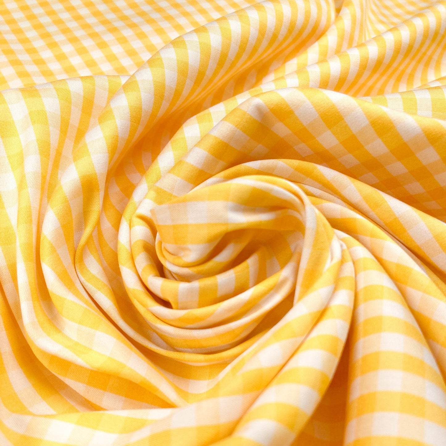 A swirl of yellow and white cotton gingham fabric