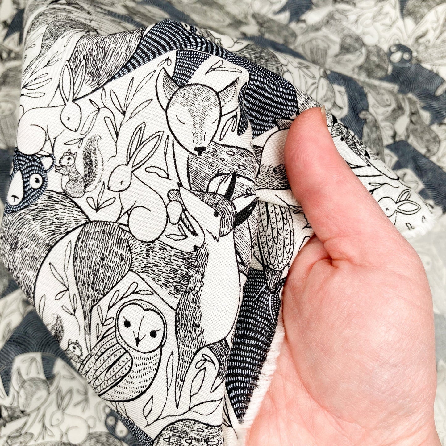 Hand holding fabric with black and white animal pattern
