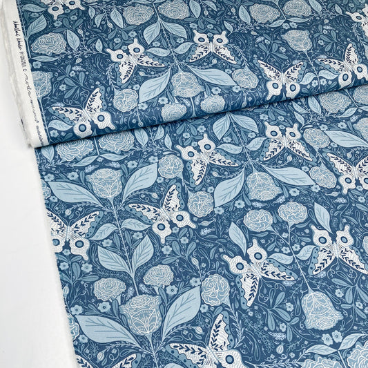 Bolt of fabric with a blue and white floral and butterfly pattern.