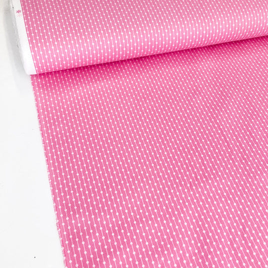 Roll of pink fabric with a subtle pattern on a white background