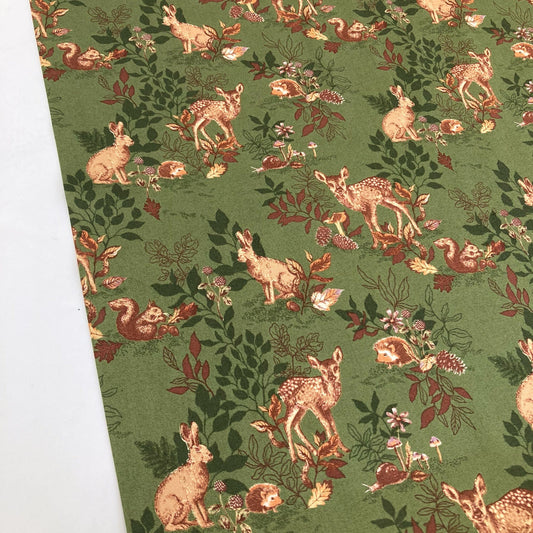 Deep green quilting cotton fabric with a retro-style woodland animal design against a white background.