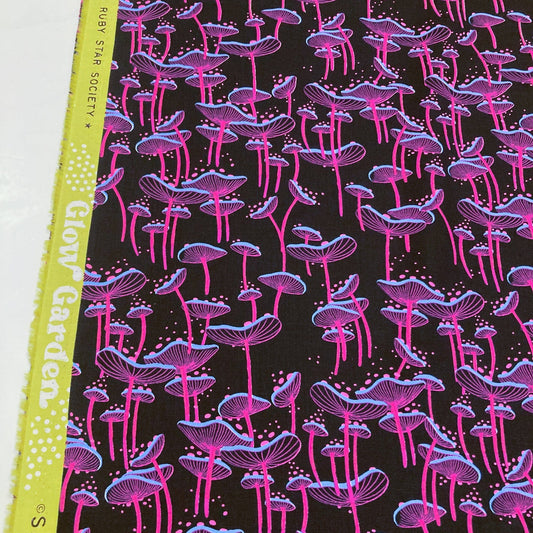 Fabric with pink and purple mushroom pattern on a black background.