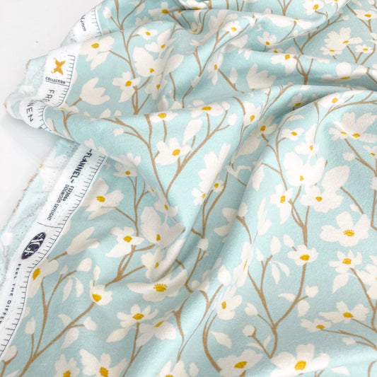 Floral fabric with white flowers on a light blue background.