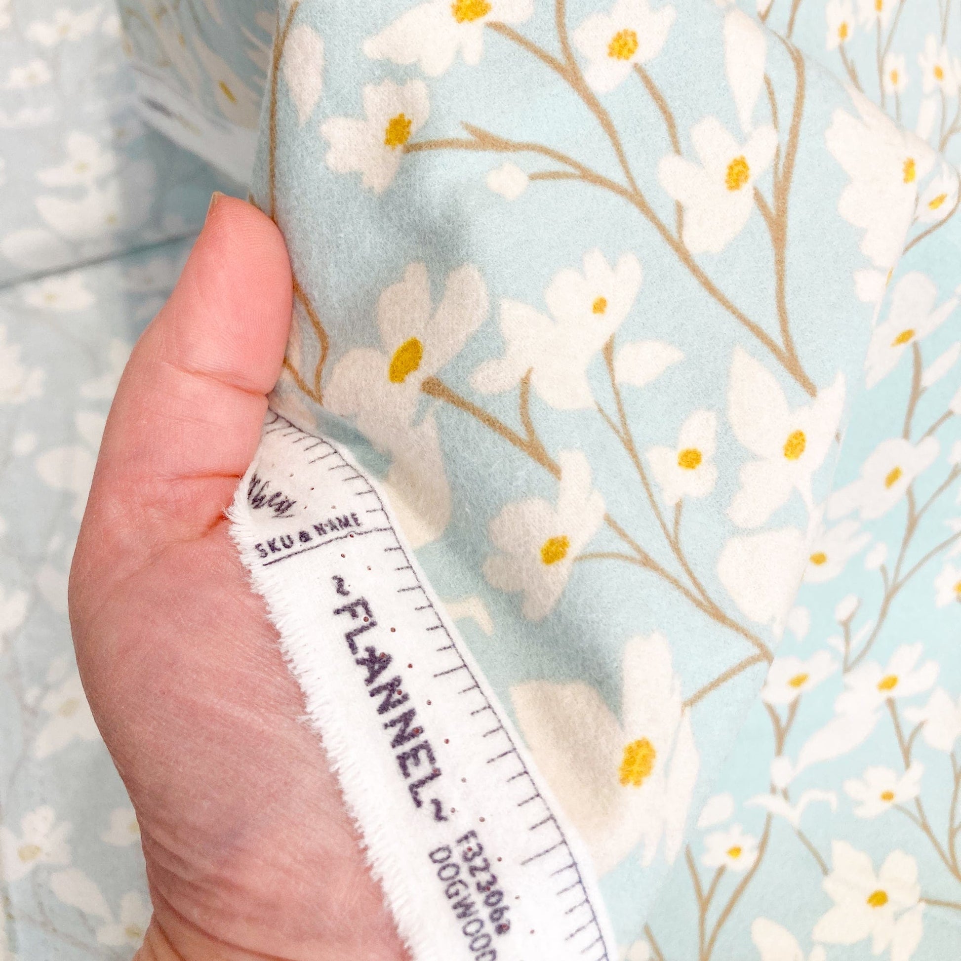 Floral brushed cotton fabric with a hand for scale