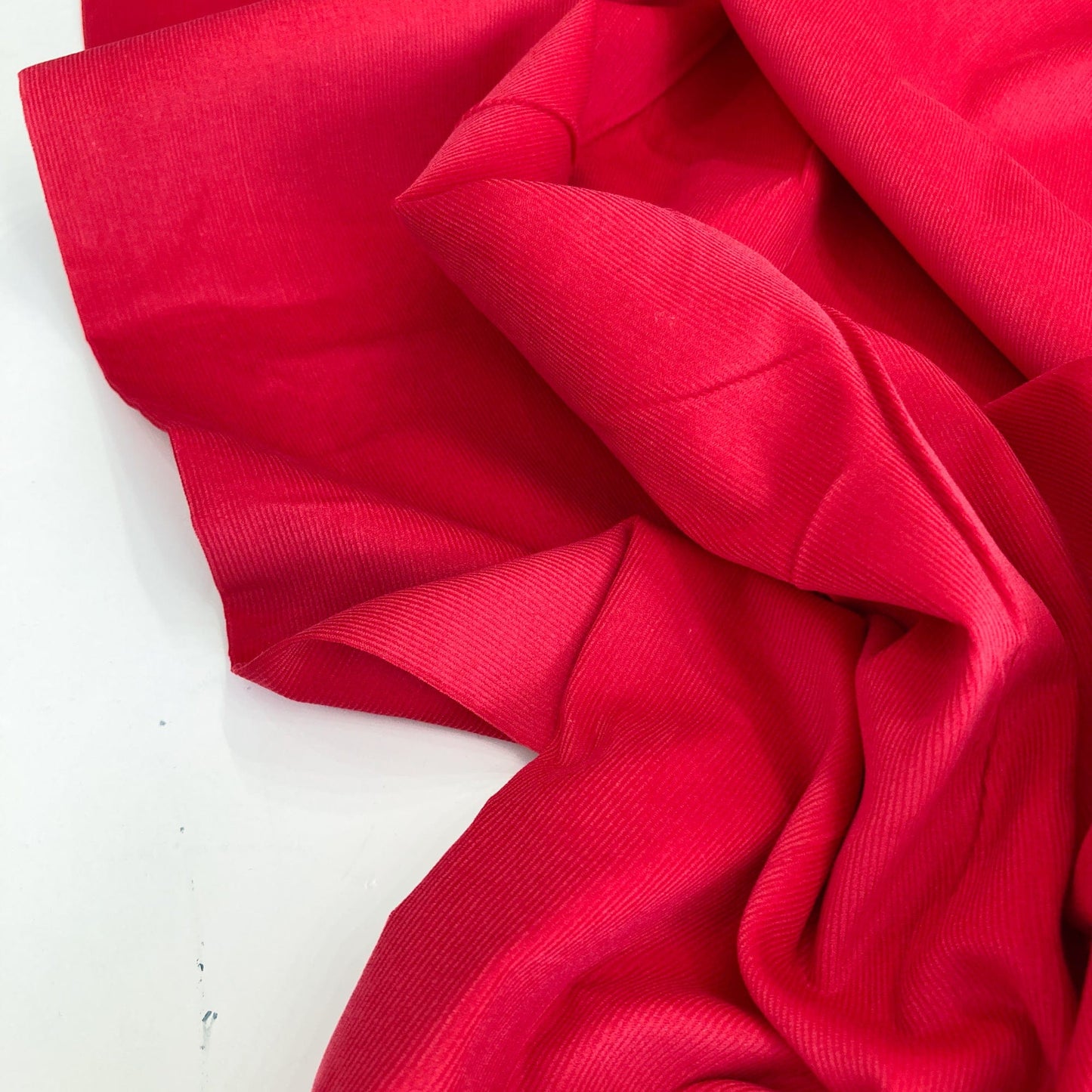 Close-up of red cotton needlecord fabric on a white background
