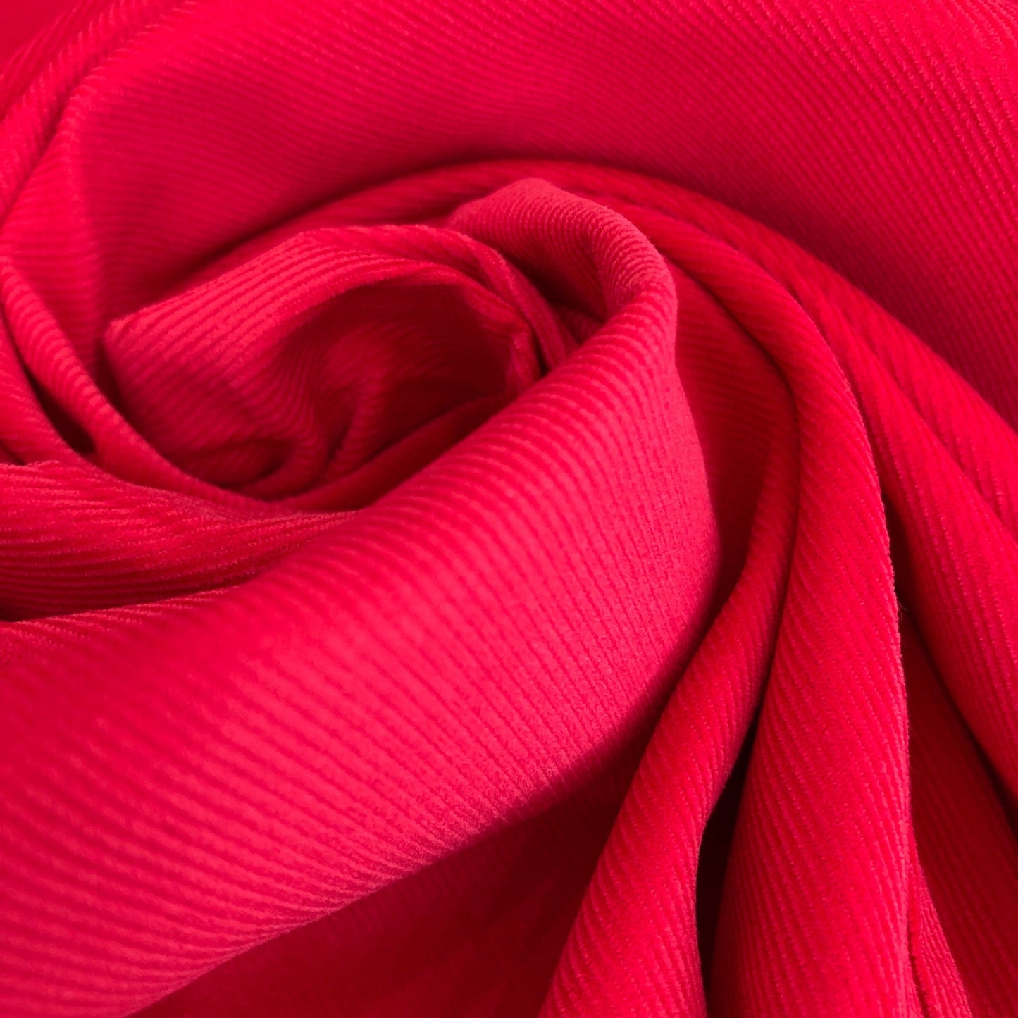 Close-up of swirled red cotton needlecord fabric 