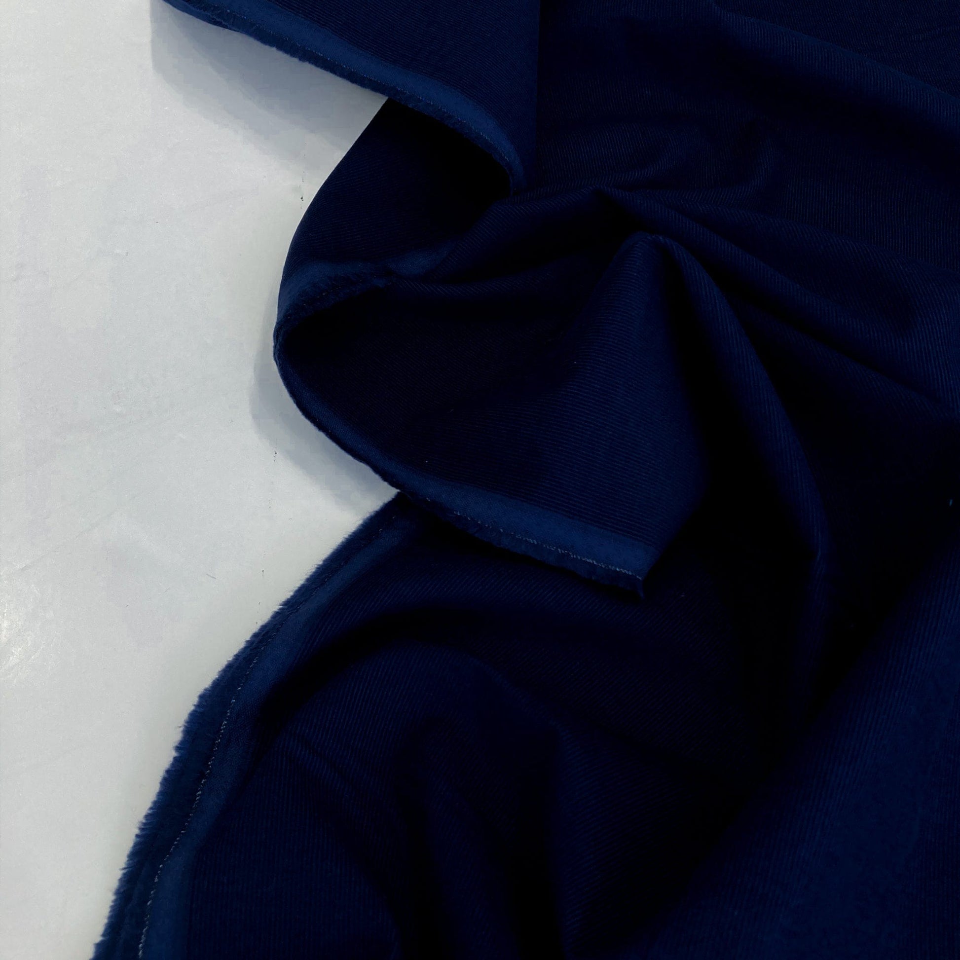 Navy blue cotton needlecord on a white background
