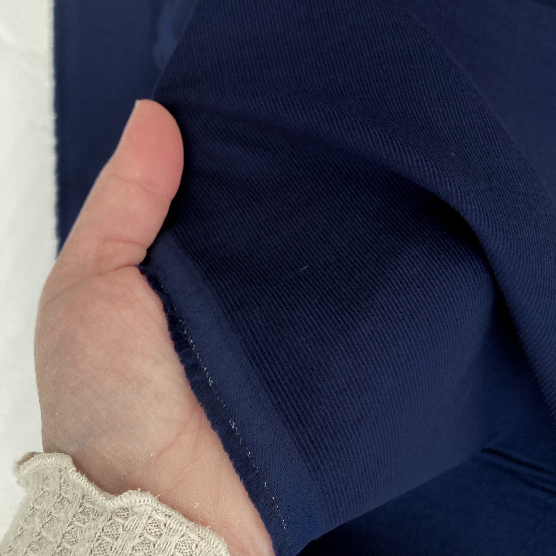 Hand holding navy blue needlecord fabric 