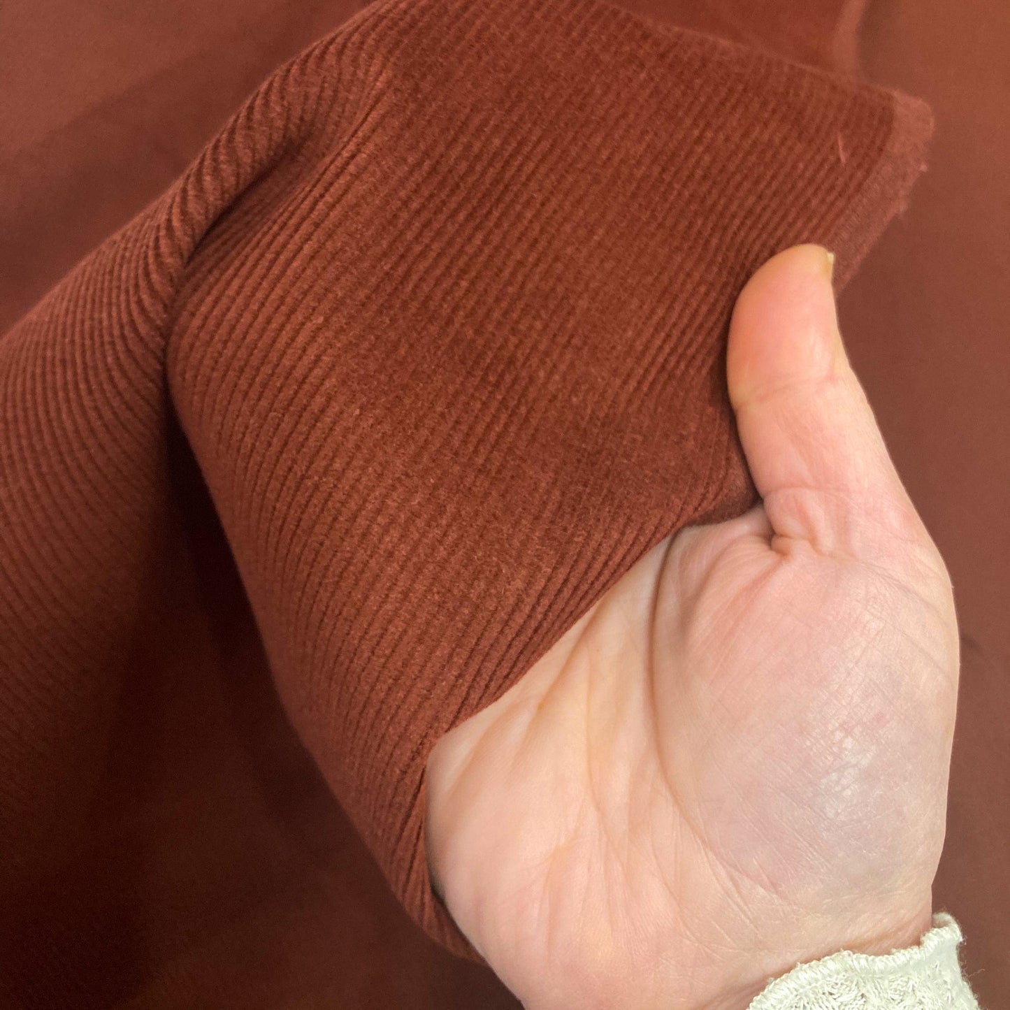 Hand holding brown corduroy fabric 