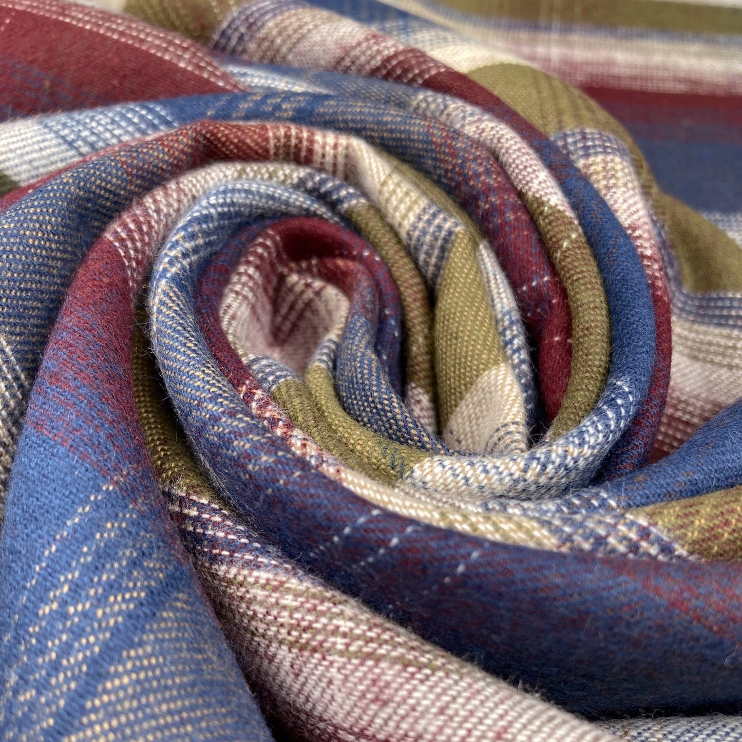 Swirl of flannel fabric with a check weave in blue, green and burgundy