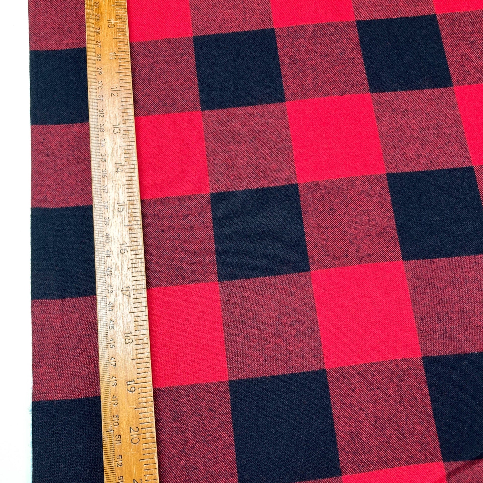 Red and black buffalo check flannel twill fabric with a ruler for scale
