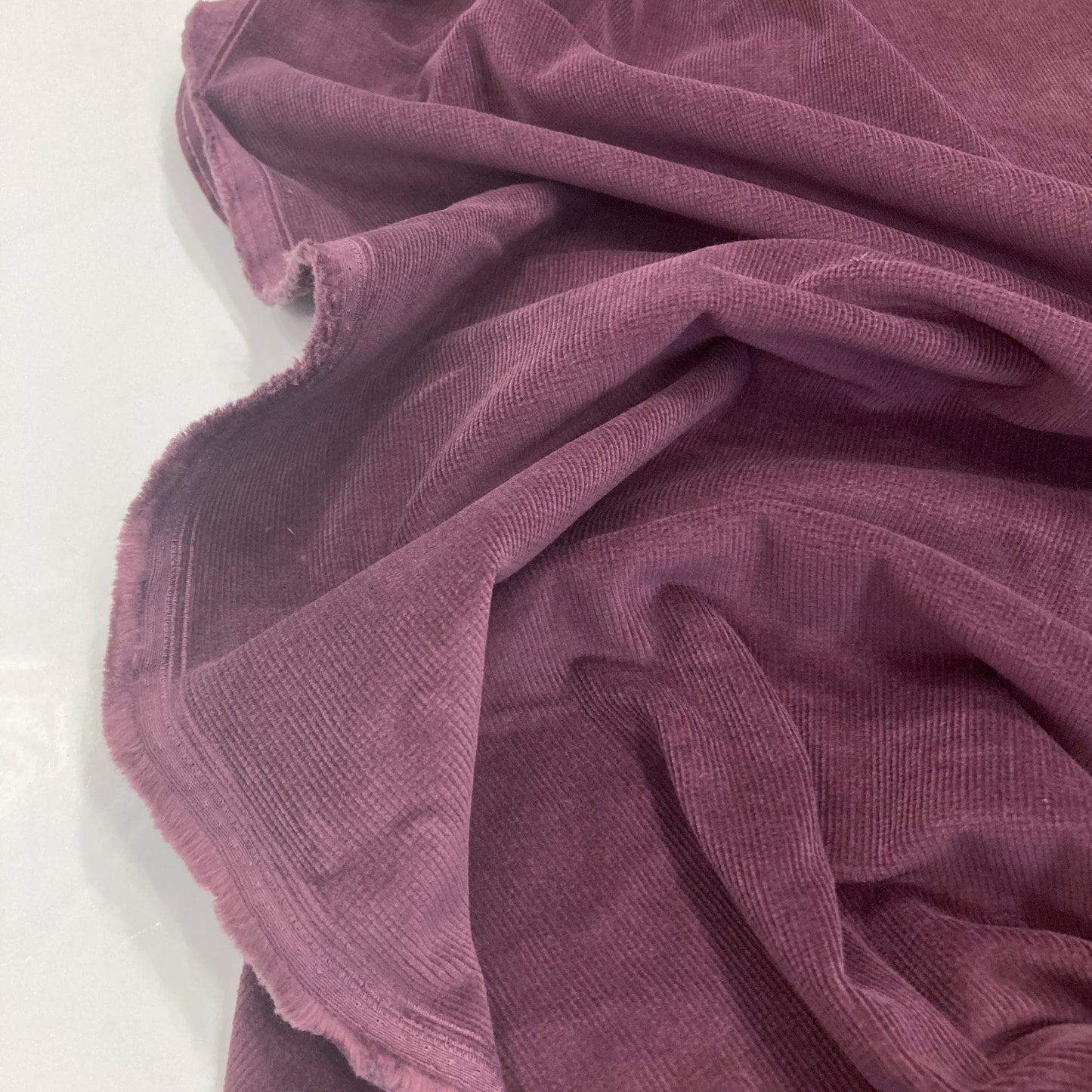 Close-up of purple corduroy fabric on a white background