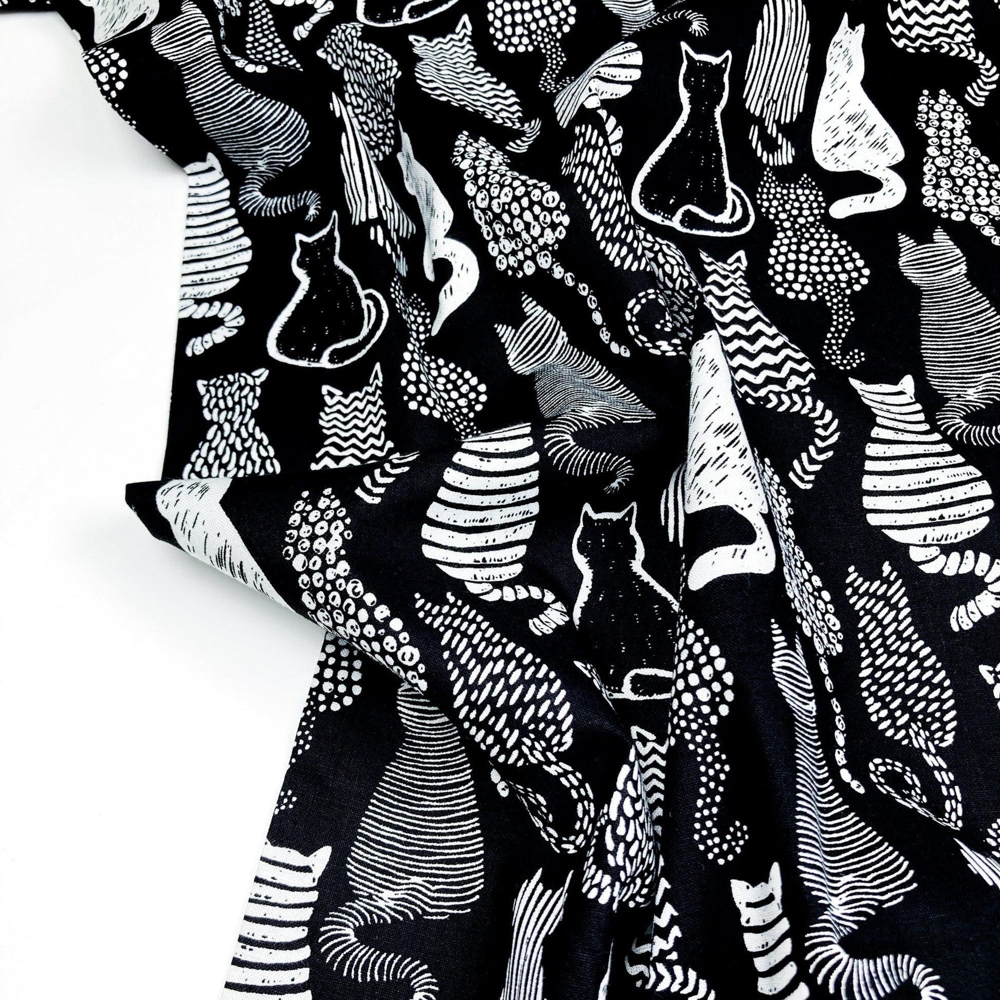 Cotton Fabric with a graphic style cat print in black and white.