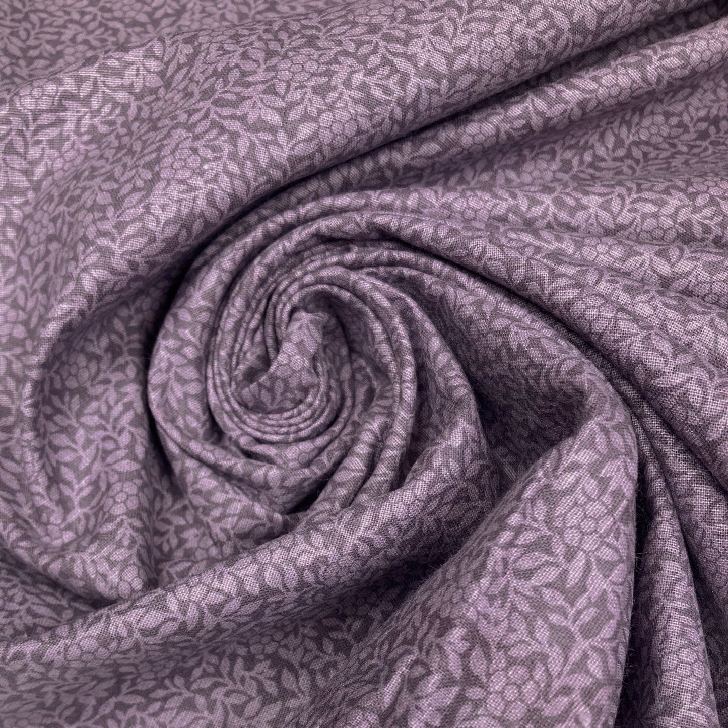 Swirl of purple cotton quiltback fabric with a small floral pattern 