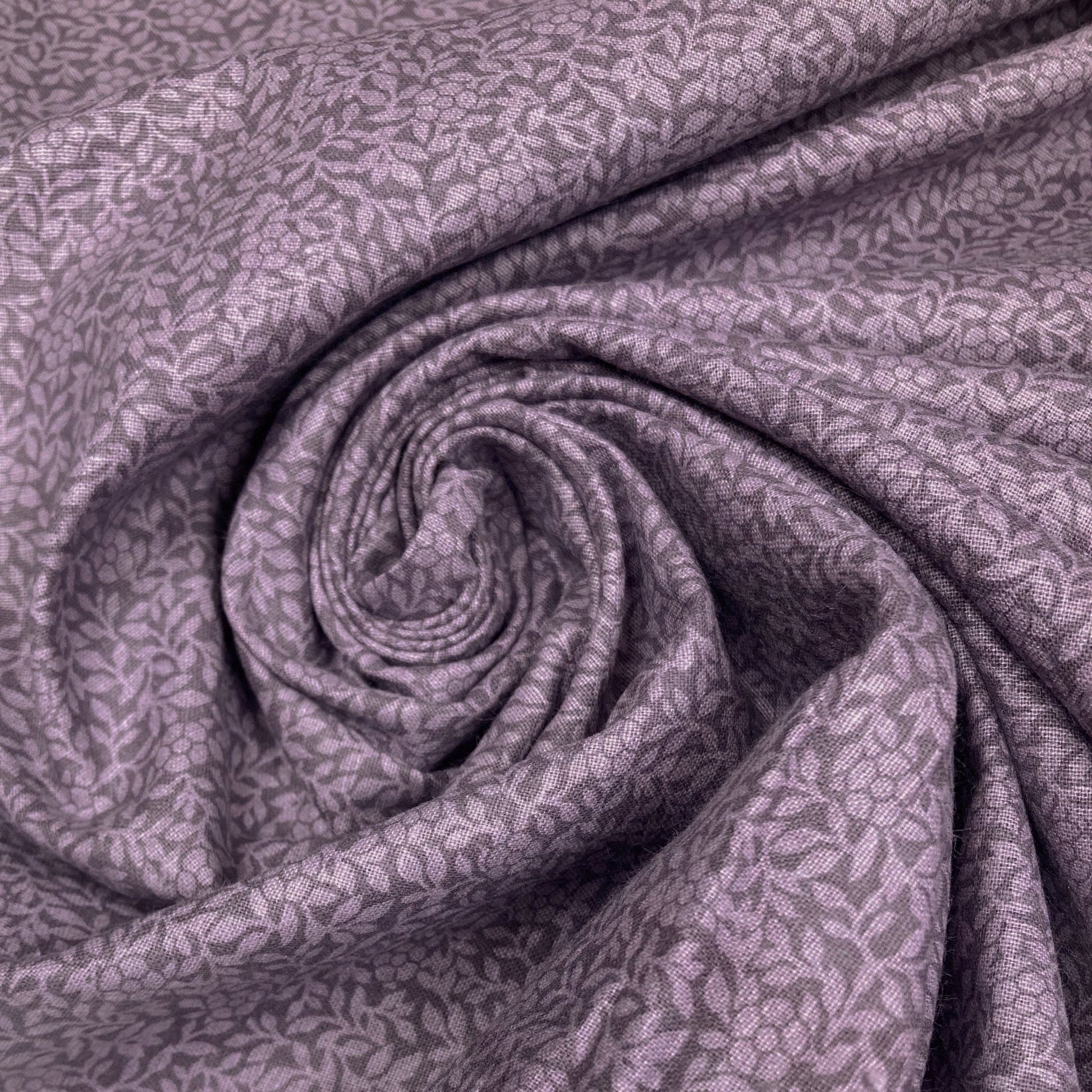 Swirl of purple cotton quiltback fabric with a small floral pattern 