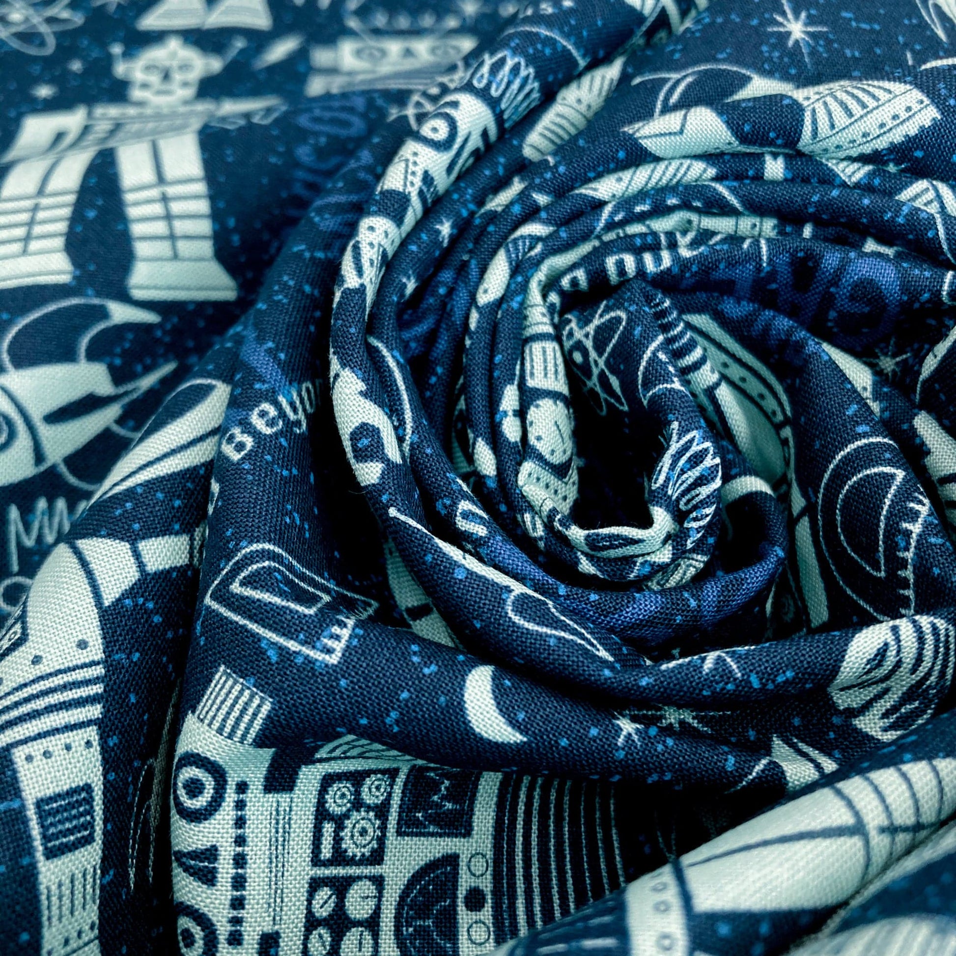 Swirl of quilting cotton fabric with robot pattern on a blue background
