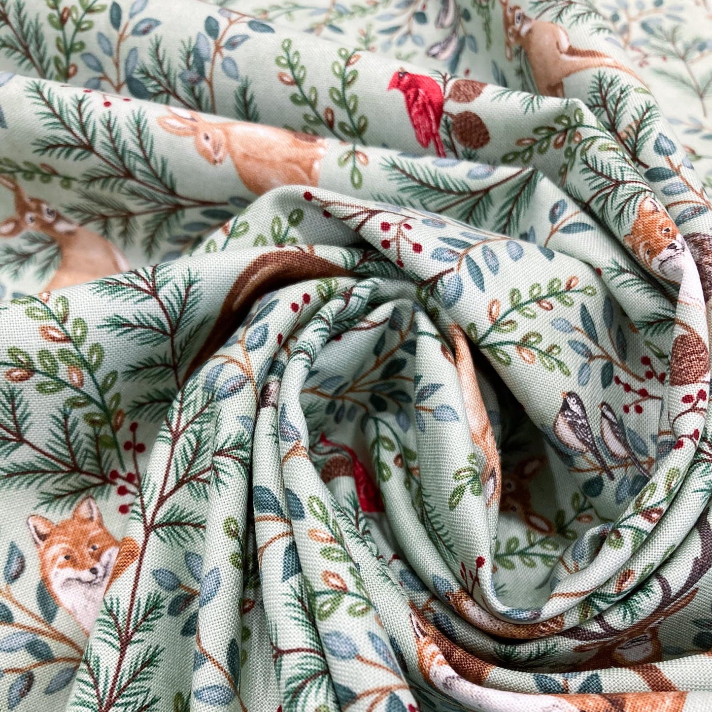 cotton fabric with nature-themed design featuring animals and plants