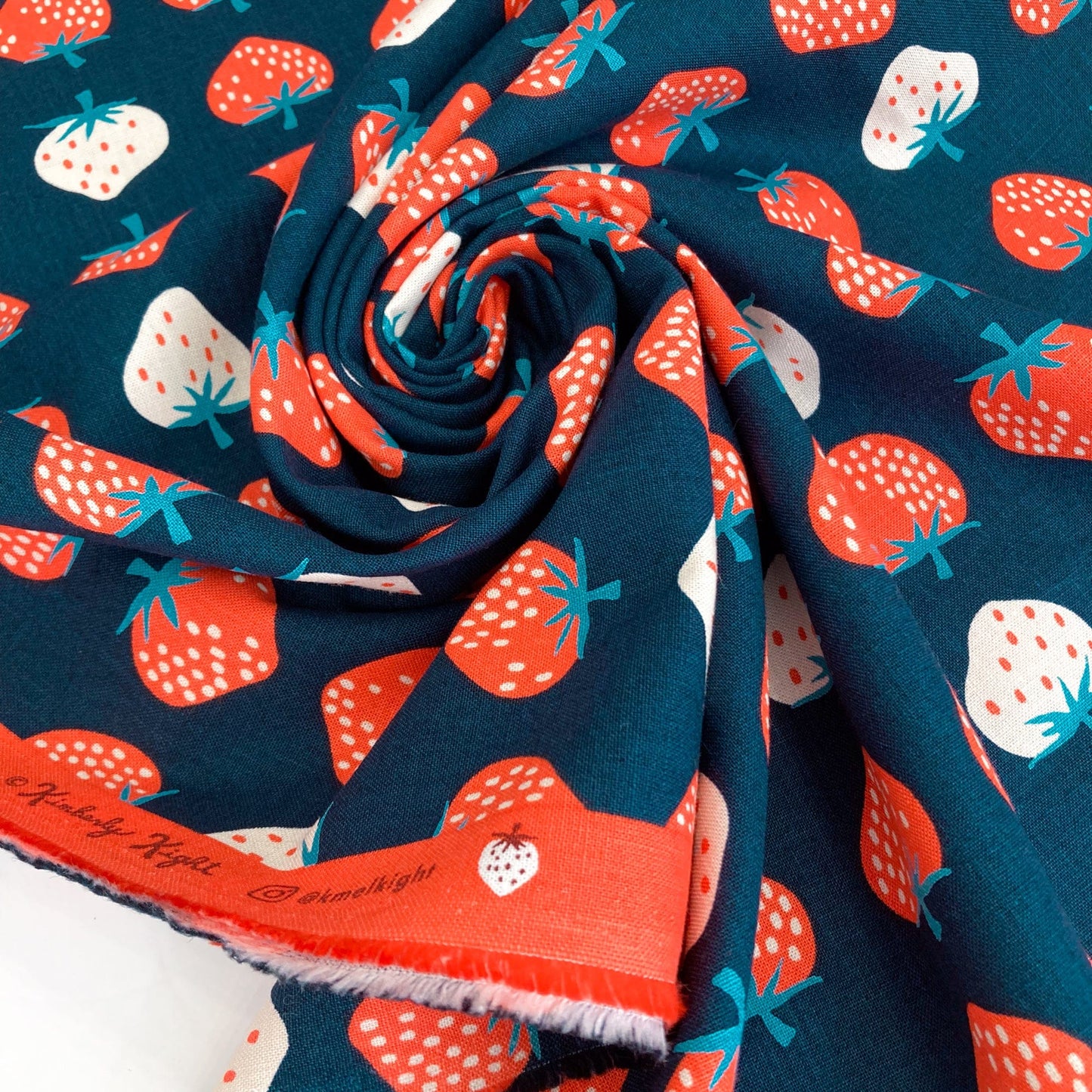 Swirl of fabric with strawberry pattern on a blue background