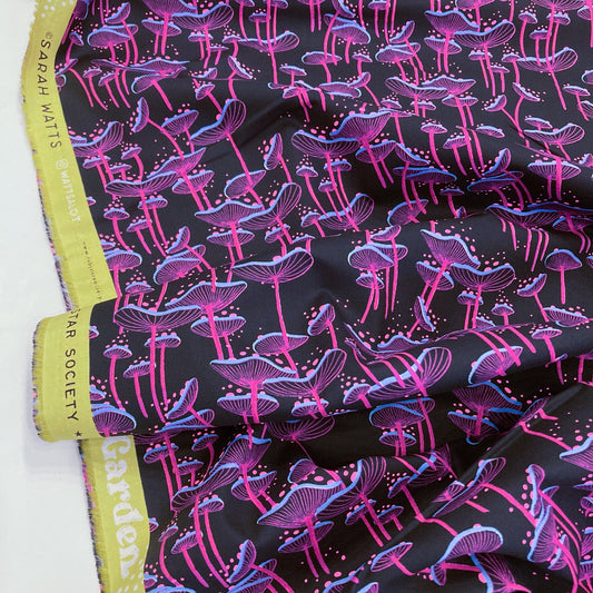 Fabric with neon pink and blue mushroom pattern on a black background.